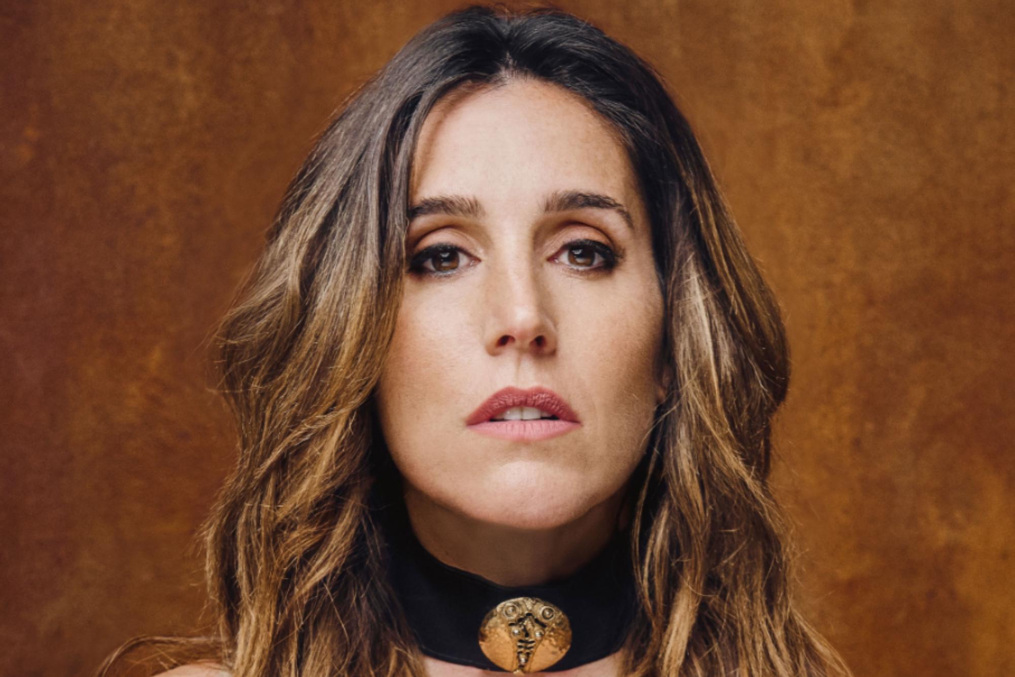 Retrato cercano de Soledad Pastorutti, con cabello castaño ondulado y una gargantilla negra con un medallón dorado.